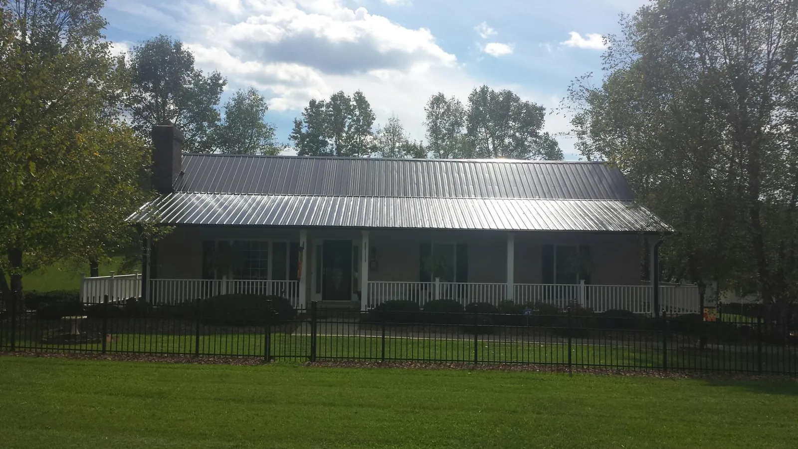 Gray metal roof on a brick ranch with a full width front porch — Gutter Guard Installation work by our crew in Auburn Hills