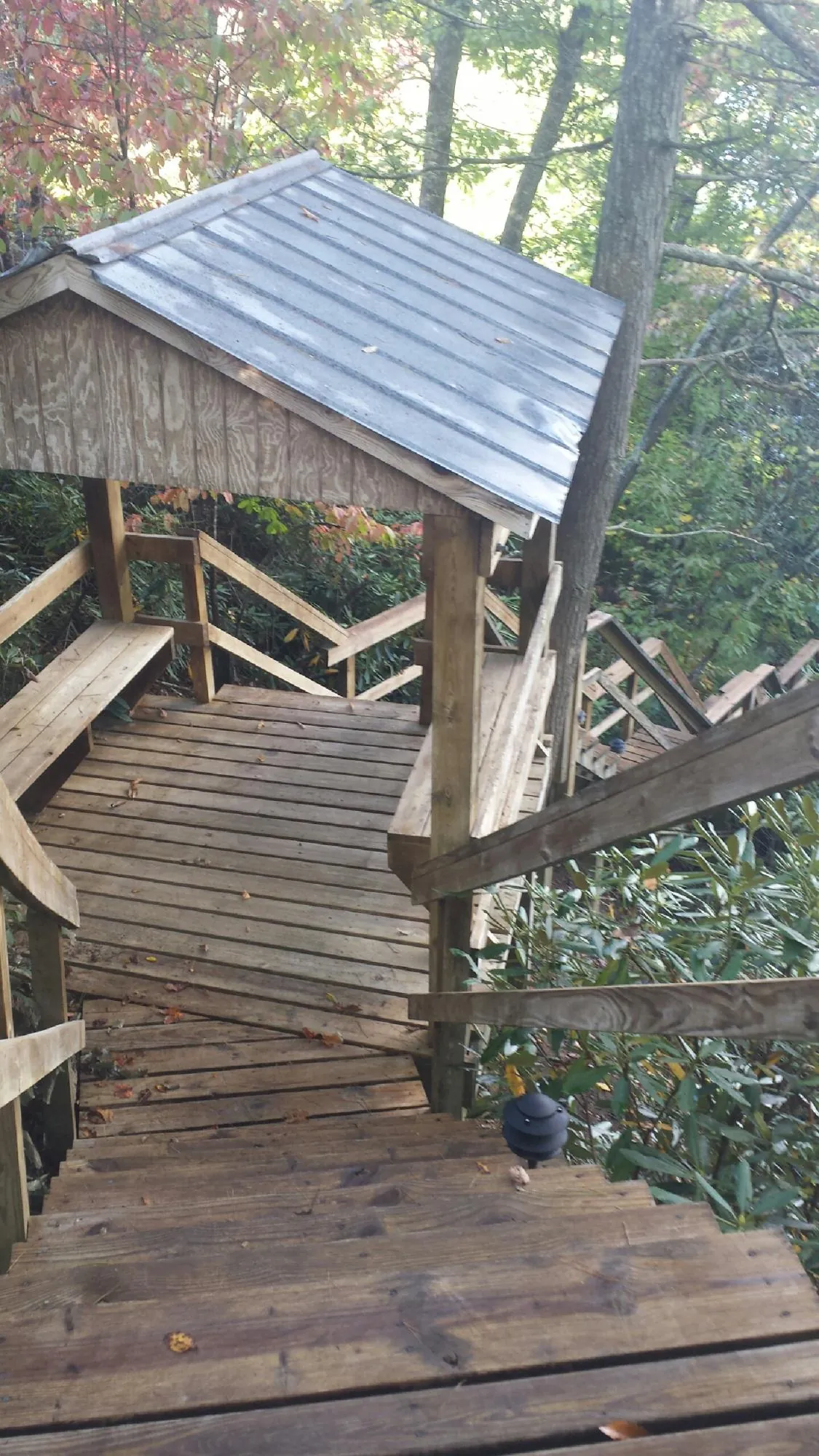 Metal roofed shelter over wooden steps on a wooded walkway — Skylight Repair & Installation work by our crew in Auburn Hills