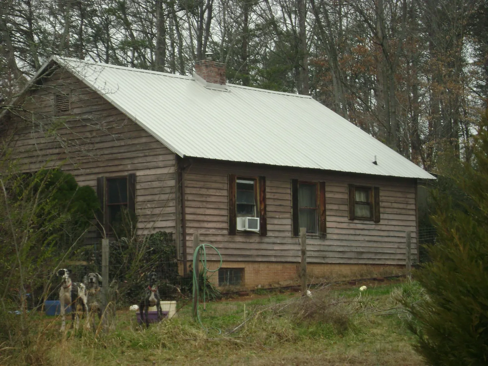 White metal roof on an old wood sided farmhouse, from a Metal Roof Installation job in Auburn Hills